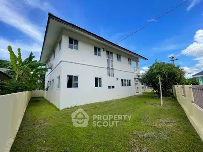 Spacious two-story house with lush green lawn and clear blue sky, perfect for family living.