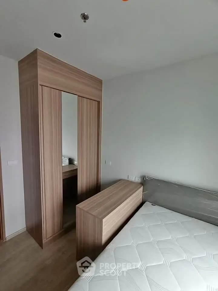 Modern bedroom with sleek wooden wardrobe and comfortable mattress, perfect for urban living.