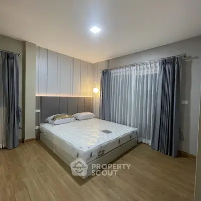 Spacious modern bedroom with elegant curtains and wooden flooring