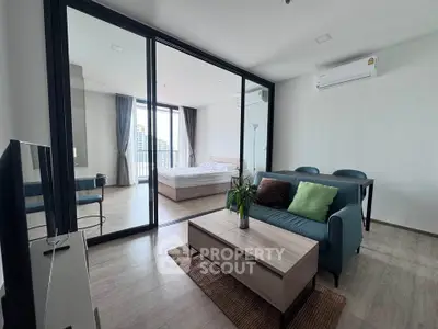 Modern open-plan living room with glass partition and city view balcony