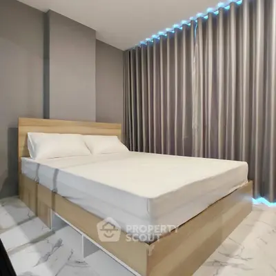 Modern bedroom with sleek design and ambient lighting, featuring a comfortable bed and stylish curtains.
