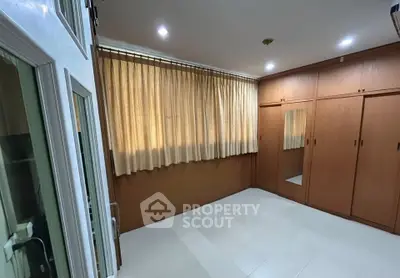 Spacious bedroom with built-in wardrobes and large window for natural light.