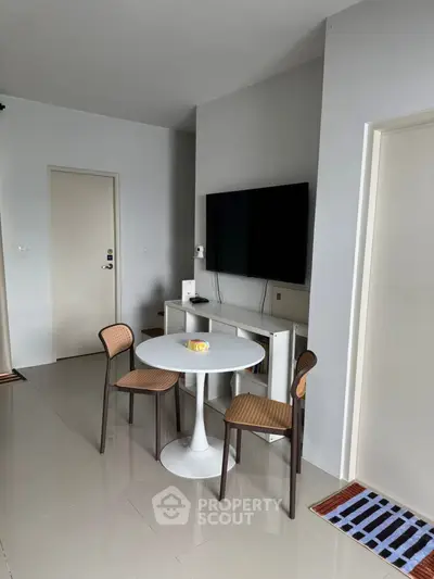 Modern living room with sleek TV setup and stylish dining area.