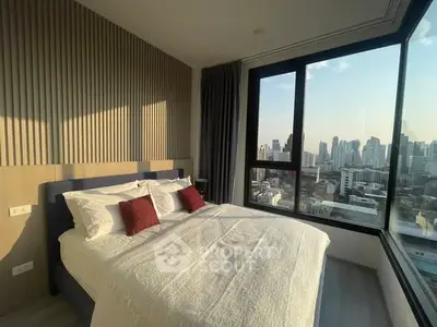 Modern bedroom with large windows offering stunning city skyline views