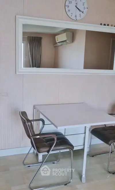Chic dining area with modern chairs and wall mirror in stylish apartment.