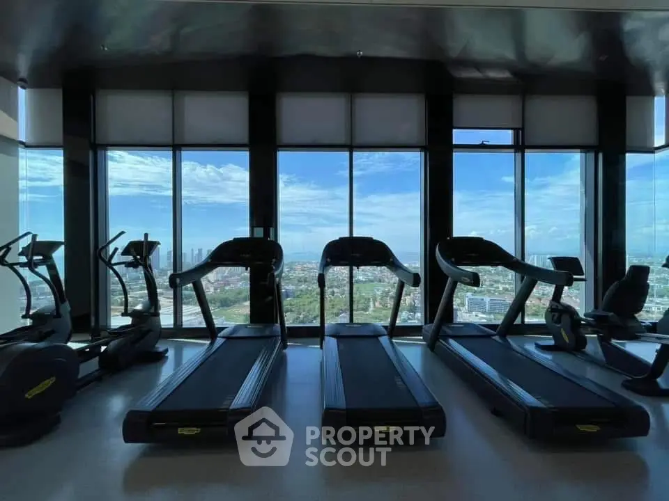 Luxurious gym with panoramic city views and modern fitness equipment.