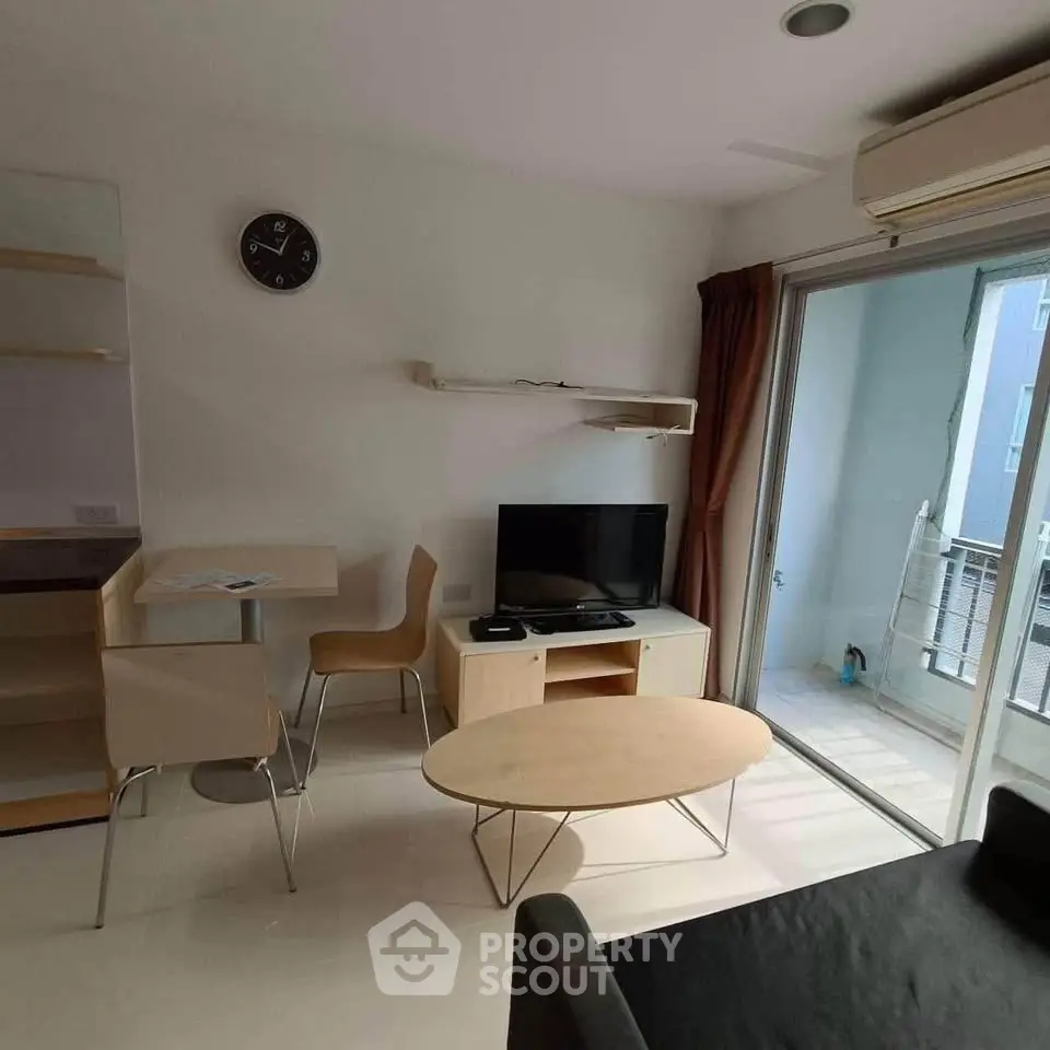 Modern living room with TV, dining area, and balcony access in a stylish apartment.