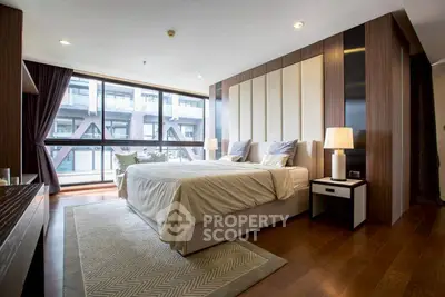 Luxurious bedroom with modern decor and large windows offering city view