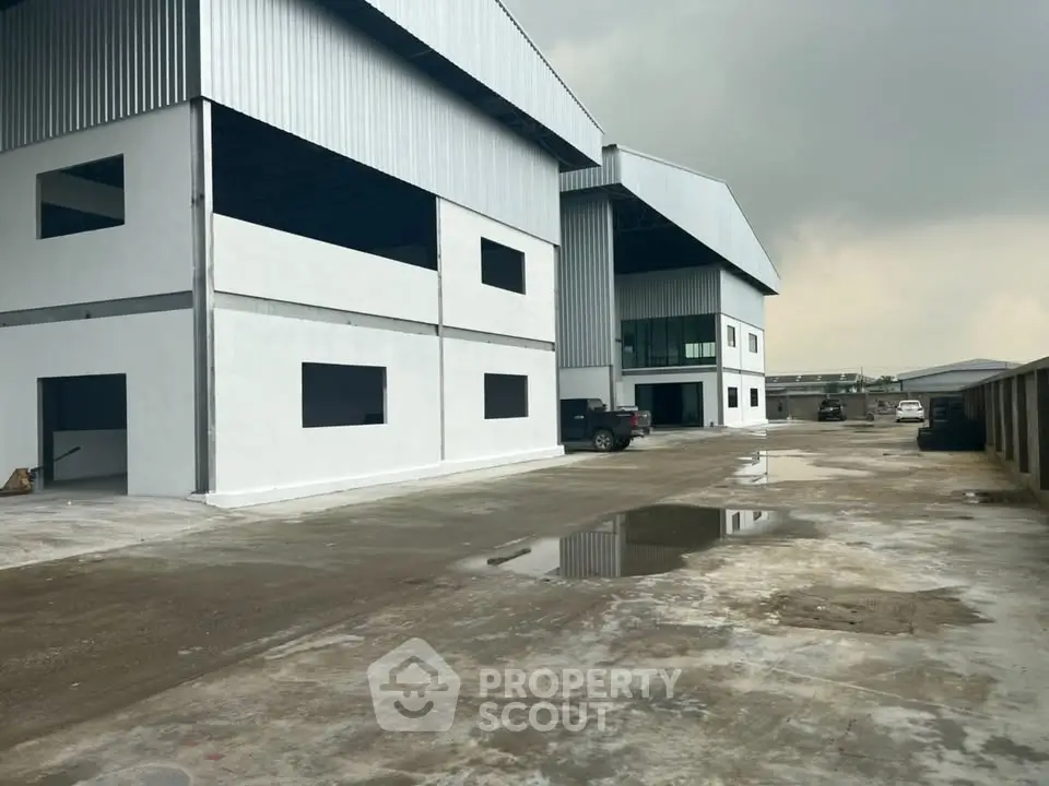 Spacious industrial warehouse exterior with ample parking and modern design.