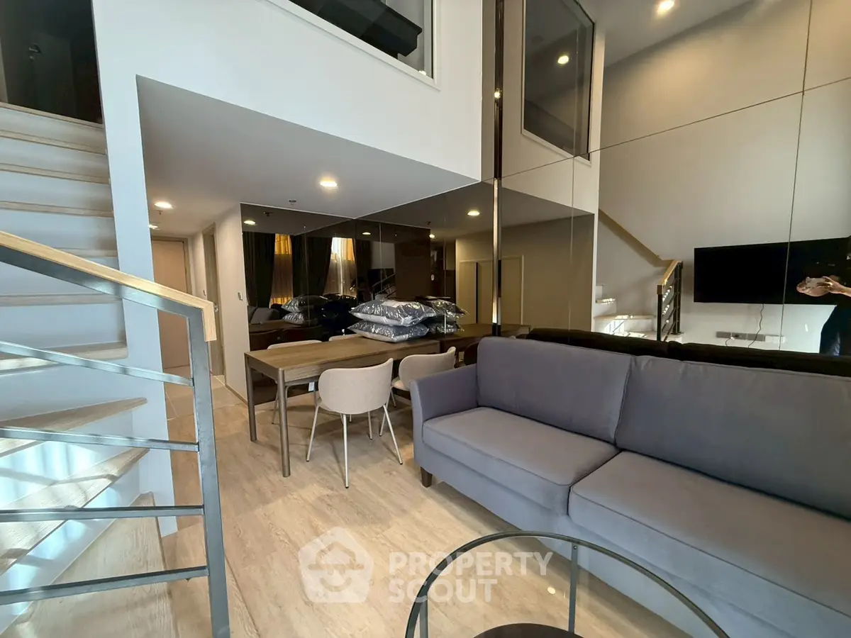 Modern duplex living room with stylish furniture and mirrored wall