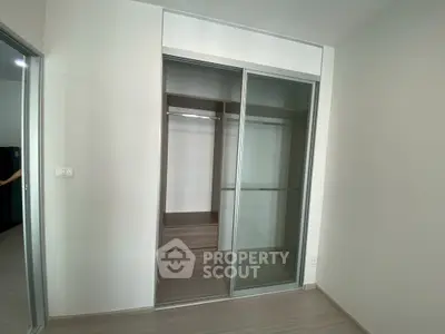 Modern built-in closet with sliding glass doors in a minimalist room