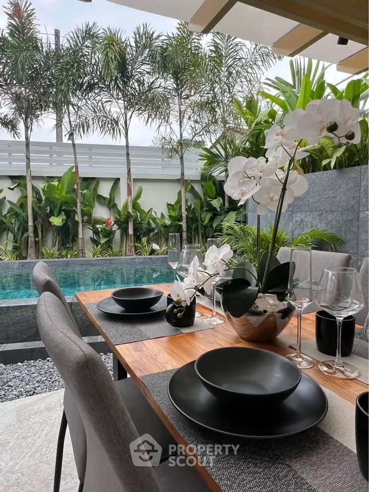 Luxurious outdoor dining area with elegant table setting by a serene pool and lush garden.