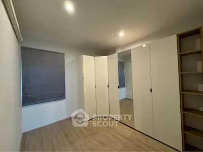 Spacious bedroom with modern wardrobe and wooden flooring