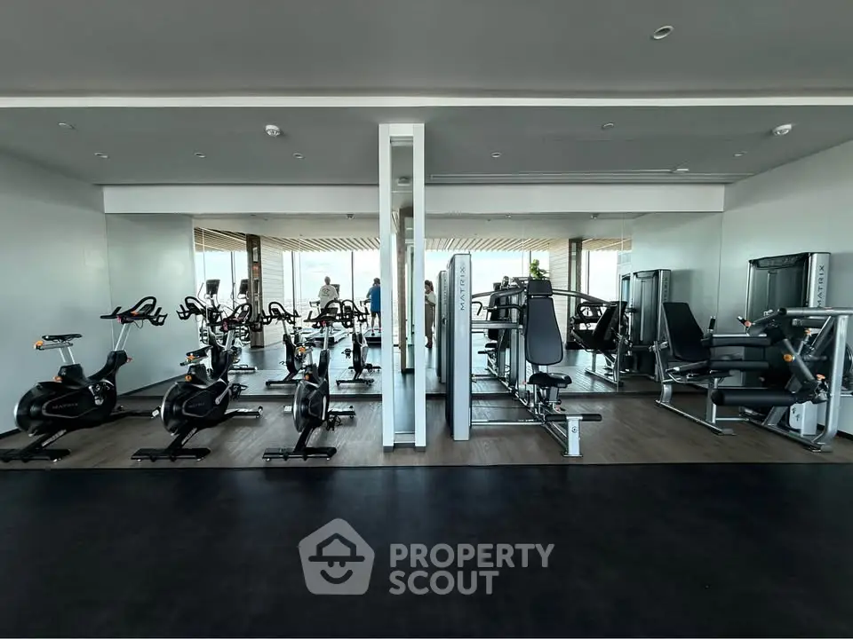 Modern gym with state-of-the-art fitness equipment and mirrored walls in luxury real estate property.