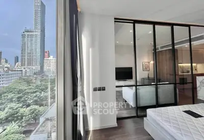 Modern bedroom with city view and sliding glass doors leading to a stylish living area.