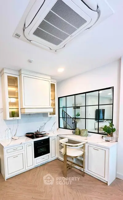Modern kitchen with sleek cabinetry, built-in oven, and stylish countertop in a contemporary home.