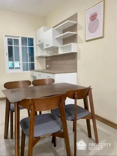 Modern dining area with wooden table and chairs, sleek cabinetry, and stylish wall art.