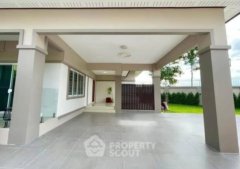 Spacious modern home entrance with tiled flooring and lush garden view.