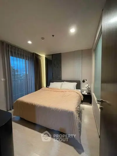 Cozy bedroom with modern decor and large window for natural light.