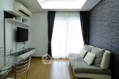 Modern living room with sleek design, featuring a cozy sofa, wall-mounted TV, and elegant curtains.