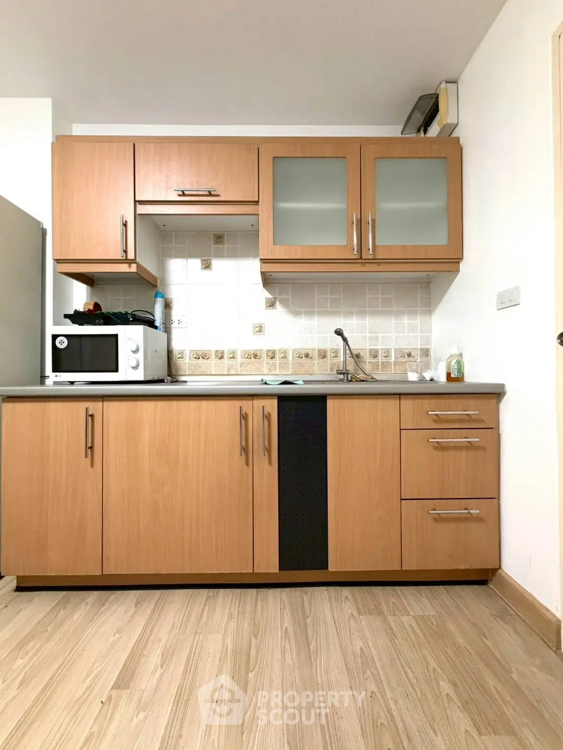 Modern kitchen with wooden cabinets and sleek appliances in a cozy apartment