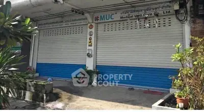 Commercial property with closed shutters and signage, ideal for business opportunities.