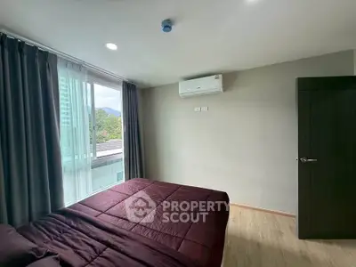 Modern bedroom with large window and air conditioning, offering a serene view.