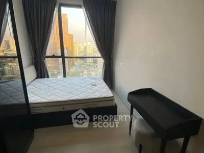 Modern bedroom with city view, featuring a cozy bed and sleek furniture.