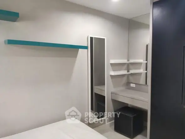 Modern minimalist bedroom with sleek shelves and vanity area.
