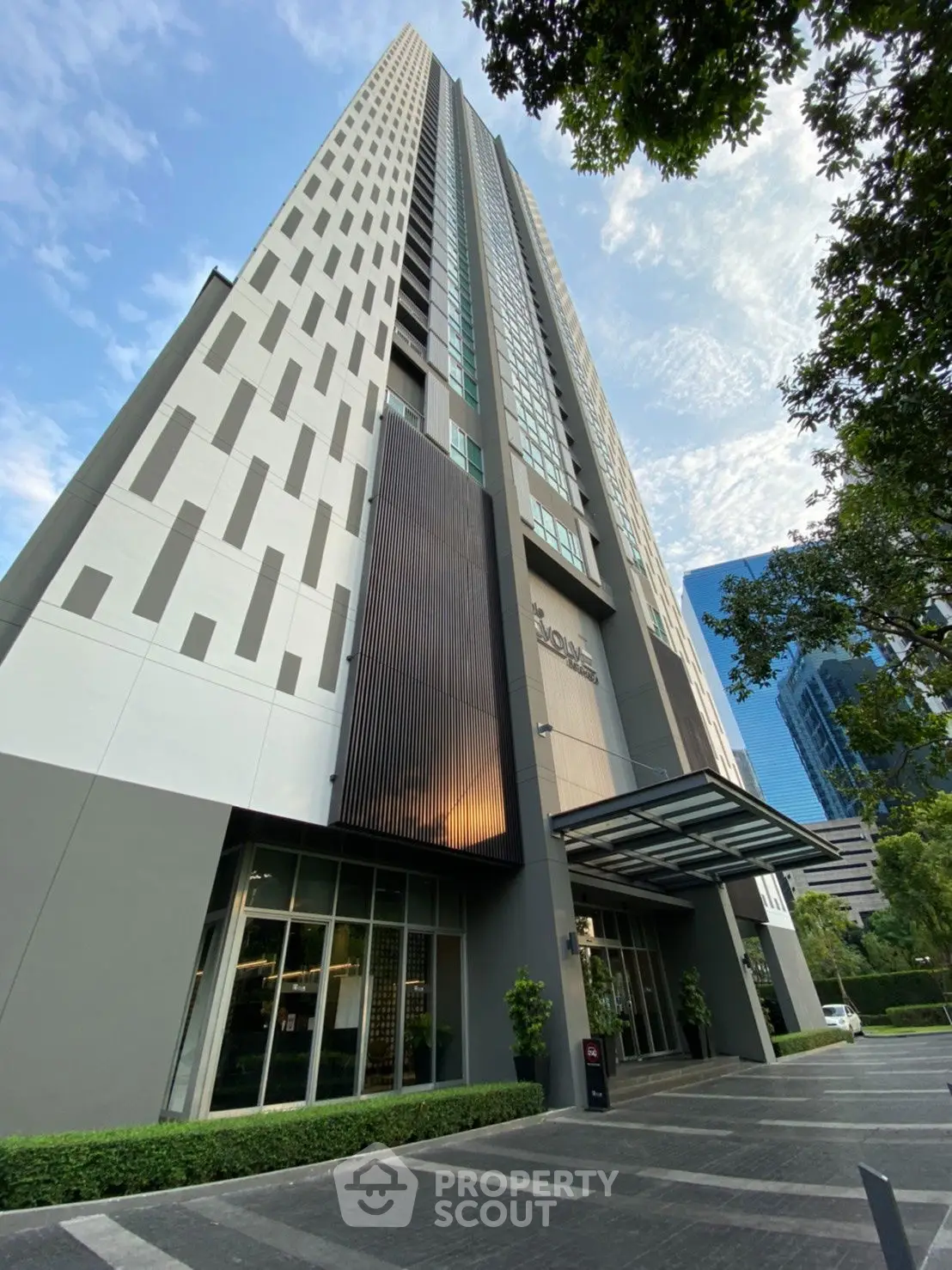 Modern high-rise building exterior with sleek design and lush greenery