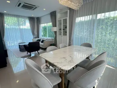 Elegant living and dining area with modern furniture and large windows for natural light.