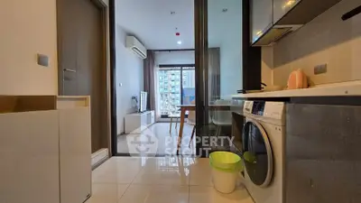 Modern apartment interior with open kitchen and living room, featuring sleek appliances and stylish decor.