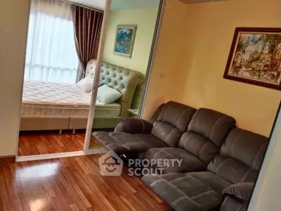 Cozy bedroom with plush bed and stylish sofa, featuring elegant wooden flooring and tasteful wall art.