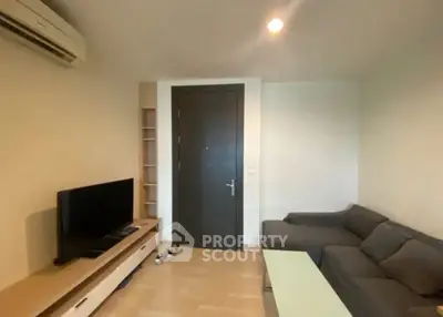 Cozy living room with modern sofa and entertainment center, perfect for relaxation.