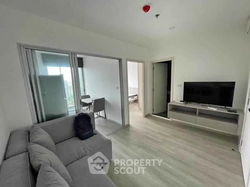 Modern living room with sleek furniture and open balcony view in a stylish apartment.