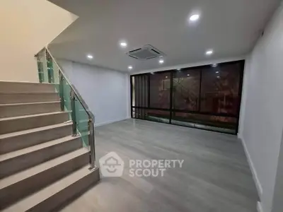 Spacious modern living room with sleek staircase and large windows
