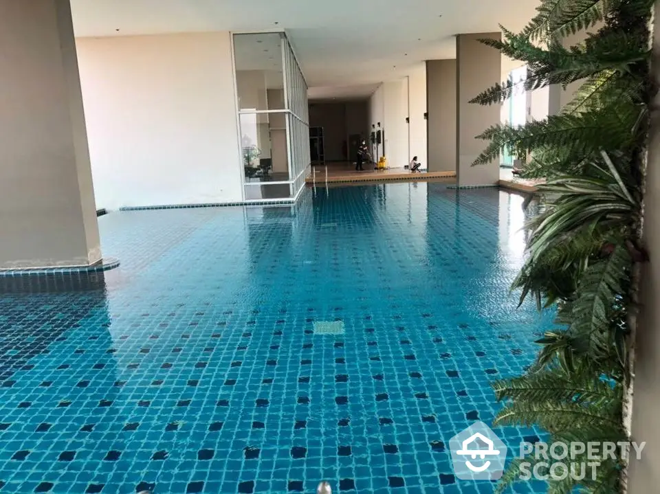 Luxurious indoor swimming pool with modern design and lush greenery, perfect for relaxation and leisure.