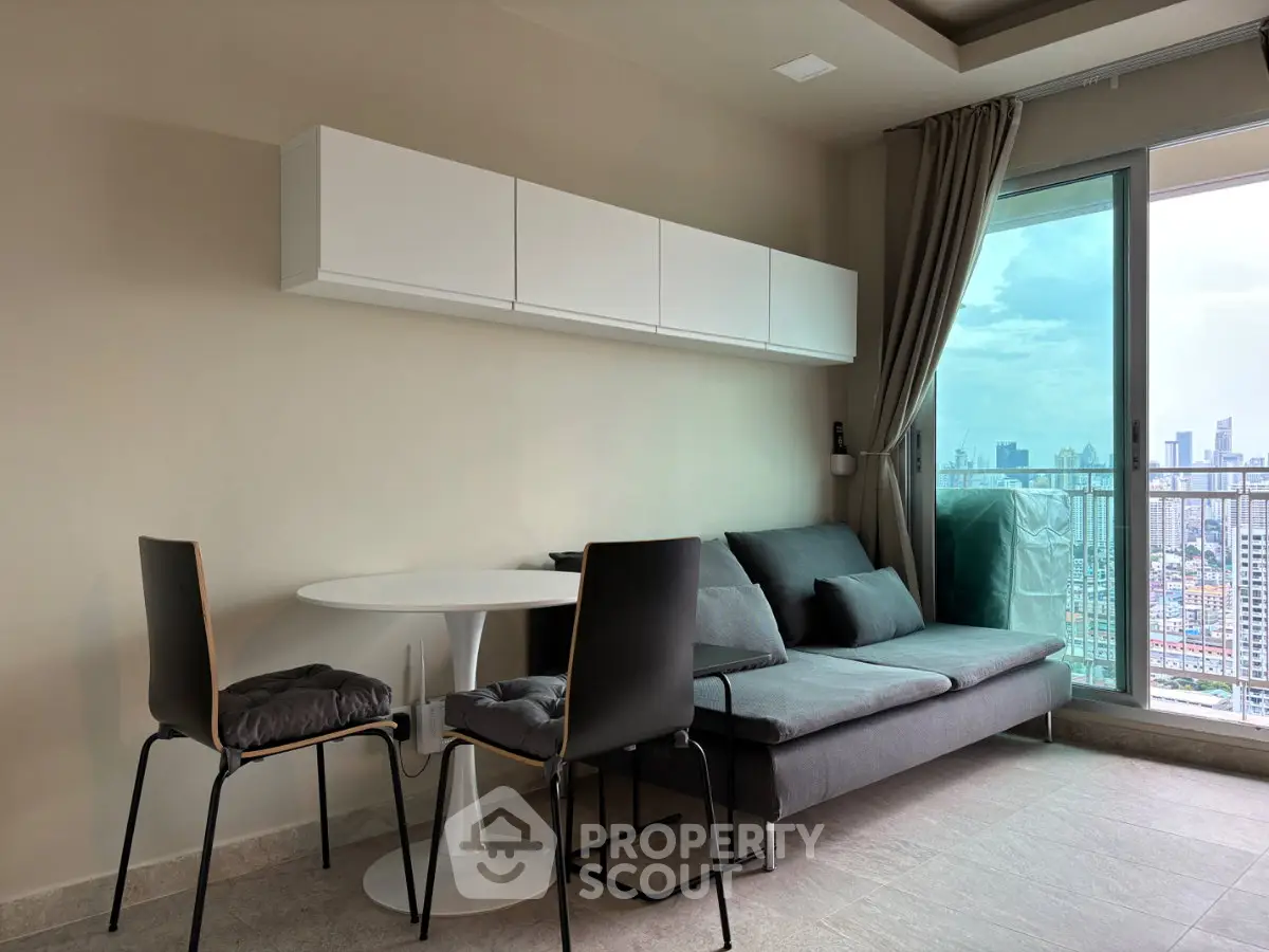 Modern living room with city view, featuring sleek furniture and large windows for natural light.