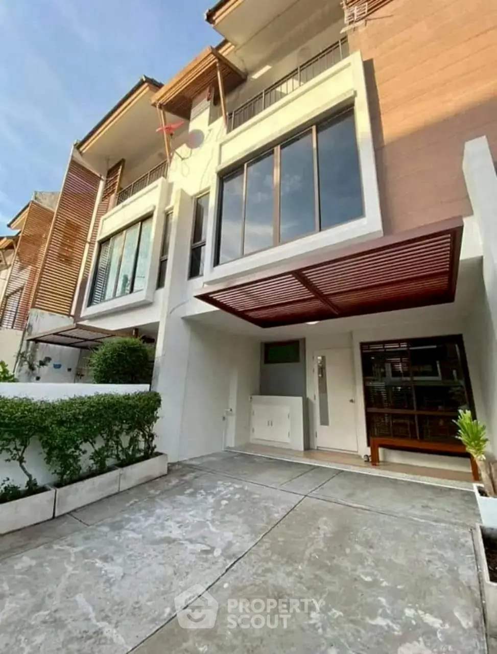 Modern townhouse exterior with spacious driveway and contemporary design elements.
