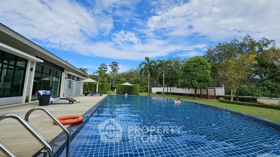 Luxurious outdoor pool area with lush greenery and modern amenities, perfect for relaxation and leisure.