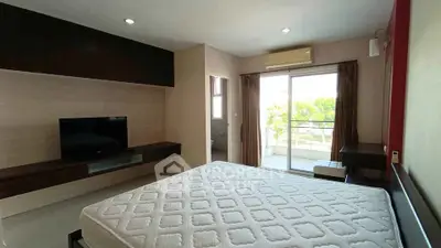 Spacious bedroom with balcony access and modern furnishings for a comfortable living experience.