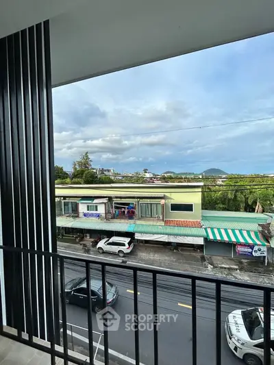 Charming balcony view overlooking a vibrant street and scenic horizon, perfect for urban living.