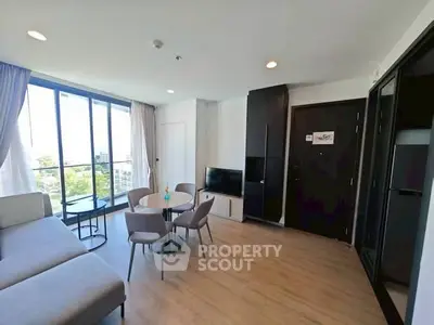 Modern living room with large windows and stylish furniture in a bright apartment.