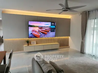 Modern living room with large TV and stylish decor, featuring elegant lighting and floor-to-ceiling curtains.