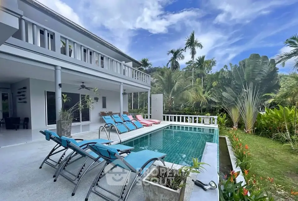 Luxurious villa with private pool and lush garden in tropical paradise setting.