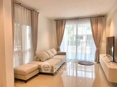Spacious living room with elegant curtains and modern furniture, perfect for relaxation and entertainment.
