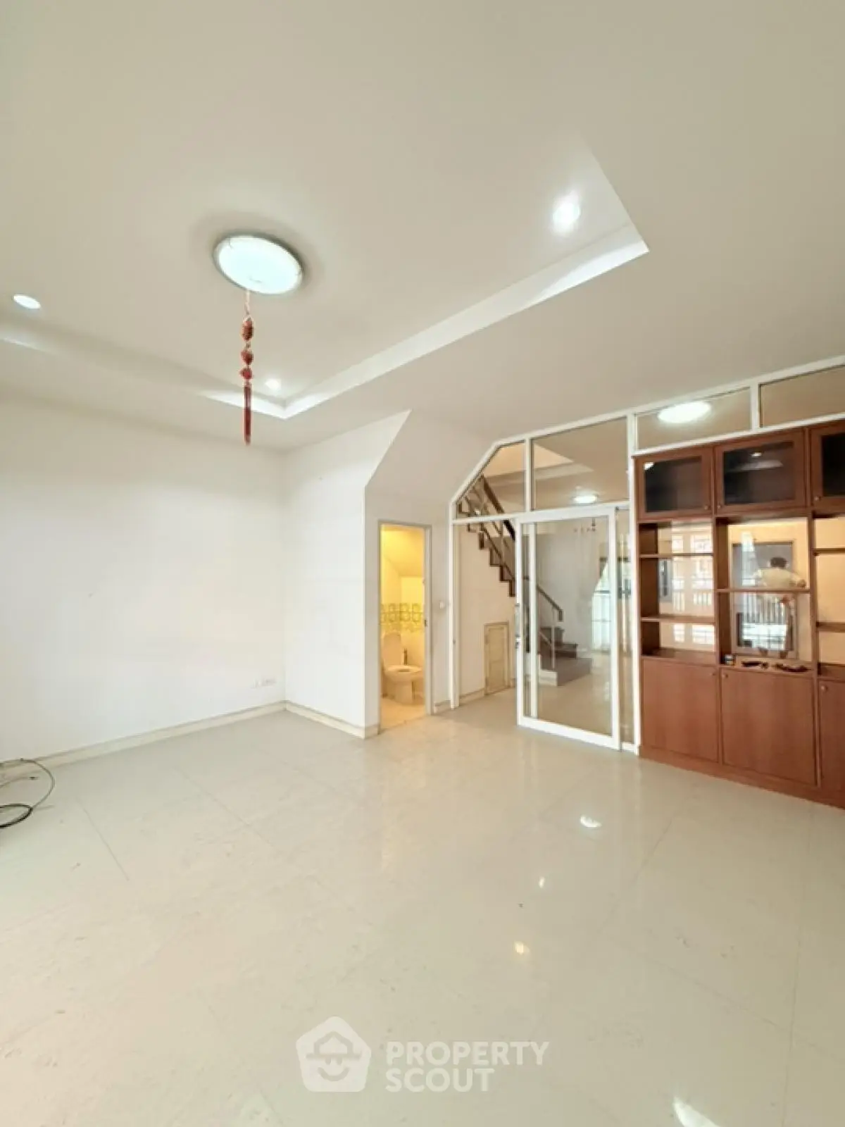 Spacious modern living room with staircase and glass partition