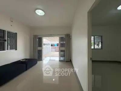 Spacious living room with modern design and large windows opening to a patio.