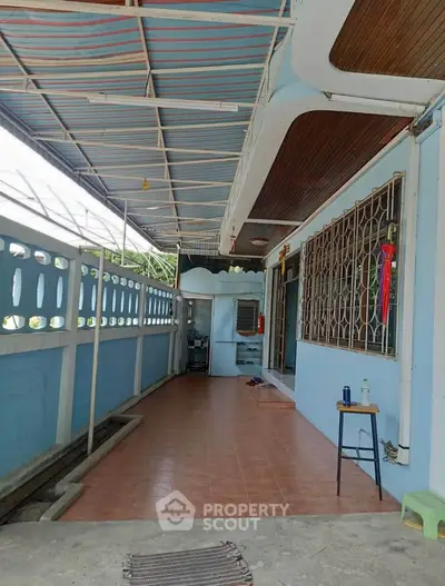 Charming covered balcony with tiled flooring and decorative railing, perfect for relaxation.