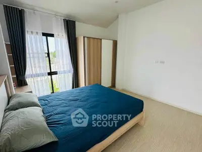 Spacious bedroom with modern decor and large window for natural light